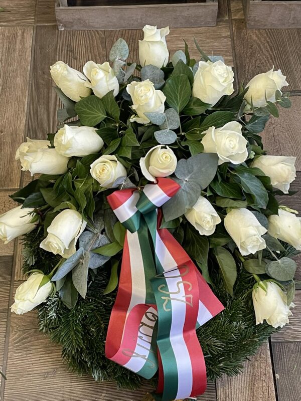 Fehér rózsa nemzeti szalaggal díszített sírcsokor