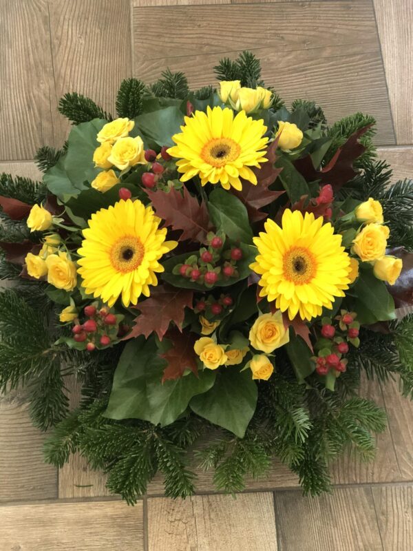 Napsugár Szerenádja - Sárga Gerbera, Sárga Rózsacsoport és Piros Bogyókkal Díszített Fekvő Koszorú